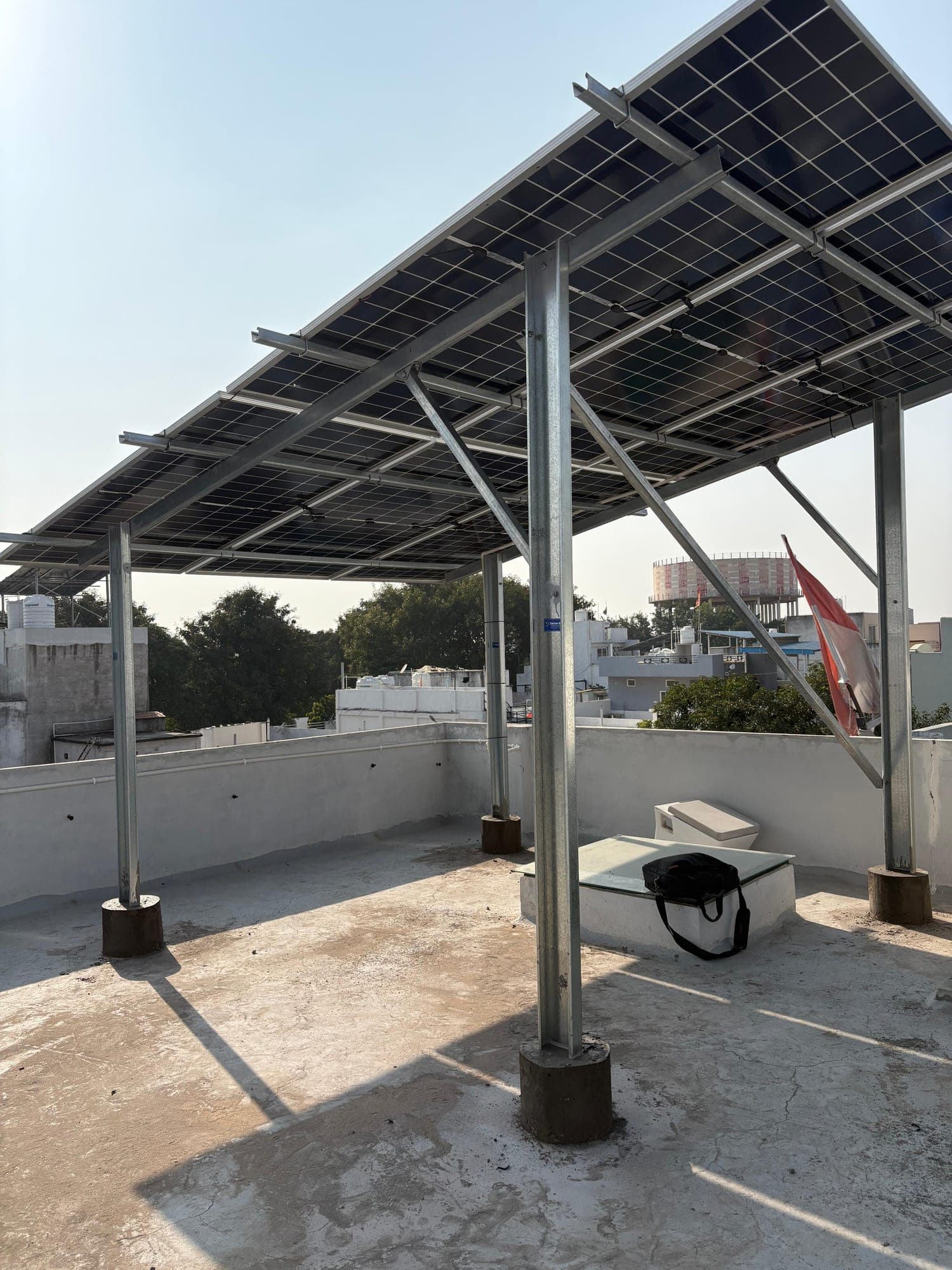 Raised galvanised solar structure on a white terrace in Indore, photographed November 2025