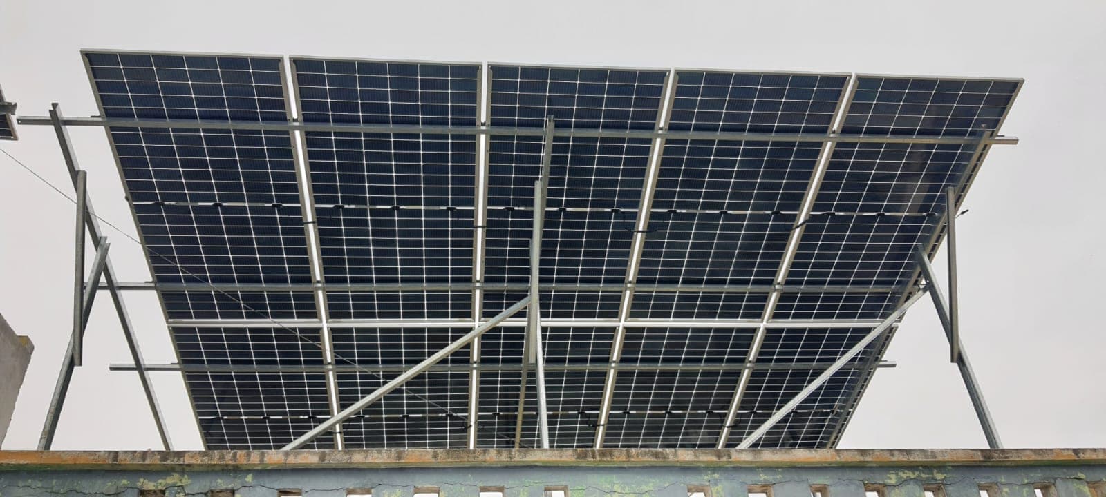 Wide view of a large elevated solar panel array under an overcast sky in Indore